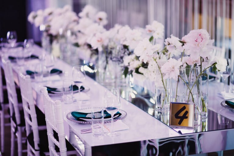 Wedding decor in restaurant with silverware, glassware, chairs and tables.