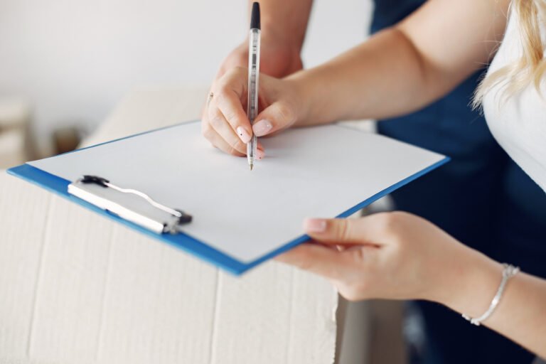 Woman writing a guest list on a piece of paper.