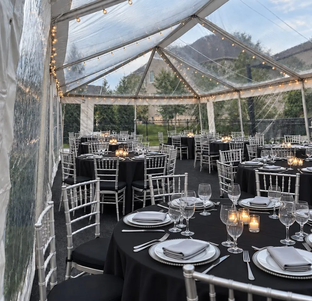 Clear tent wedding reception with black linens, silver Chiavari chairs and place settings – AAA Party Rentals, Maryland
